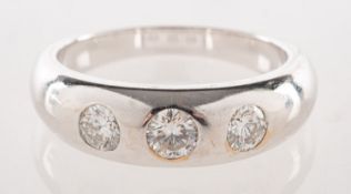 A modern 18ct white gold three stone diamond ring, flush set with three brilliant-cut diamonds,