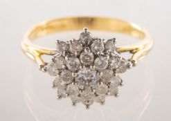 A diamond cluster ring, of tiered flowerhead form, claw set with brilliant-cut diamonds,