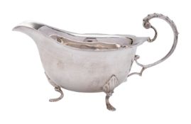 An Elizabeth II silver sauce boat, of oval form, with a wavy border and a ridged scroll handle,