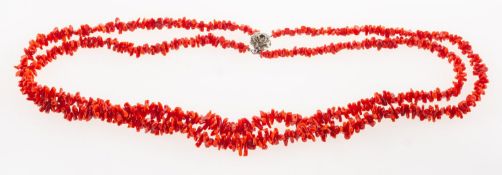A coral necklace, two rows of graduated coral beads, strung to a carved flowerhead clasp,