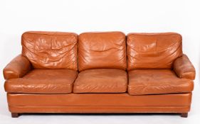 A tan leather upholstered three seat sof