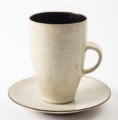 *Dame Lucie Rie DBE [1902-1995] a stone ware mug and saucer the mug with manganese interior and off