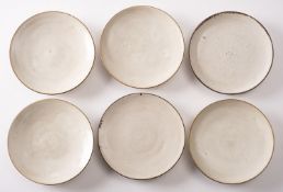 *Dame Lucie Rie DBE [1902-1995] six stone ware saucers with off white glaze and manganese rims,