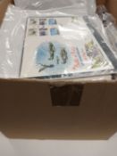 Box of stamps with omnibus sets on album pages,