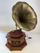 A reproduction HMV gramophone, with pressed brass horn over an octagonal base.