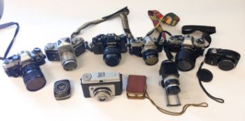 Four Olympus 35mm cameras.