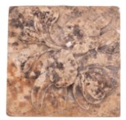 An Italian carved marble tile. Of square form and showing a bouquet of flowers, 18cm square.
