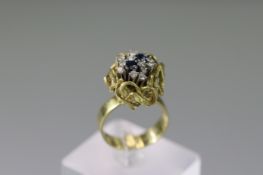 An 18 carat Gold Ring with Two Sapphires and Twelve small brilliant cut Diamonds, marked 750,