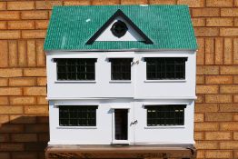 Dolls House - A large wooden dolls house in white with a green tile roof measuring 75 x 44 x 78 cm.