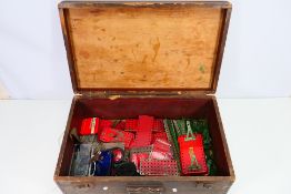 Meccano - A wooden chest with Meccano parts and pieces including wheels,