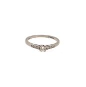 A modern 18ct gold diamond solitaire with diamond set shoulders,