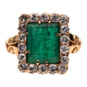 An emerald and diamond halo ring