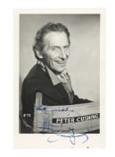Cushing (Peter) Signed vintage black and white photograph of Peter Cushing on a movie set and smilin