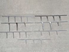 Seven painted metal shelf fittings