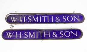Two ovoid W. H. Smith & Son reverse painted blue glass signs