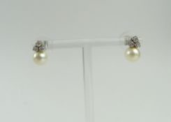 A pair of pearl and diamond stud earrings, the rou