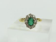 An emerald and diamond cluster ring, the oval cut