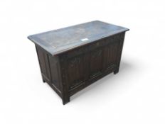 A small oak coffer with some carved features. Upon