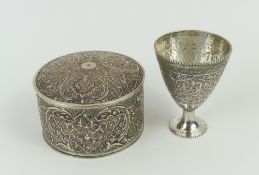 A round silver box and a small silver goblet.