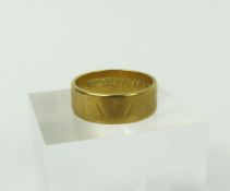 An 18ct gold wide wedding band, with worn pattern,