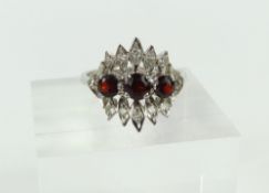 An 18ct white gold garnet and diamond dress ring,