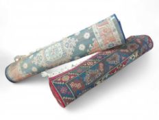 Two large rugs: one of predominantly red, blue and