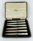 A cased set of six small silver knives with nacre
