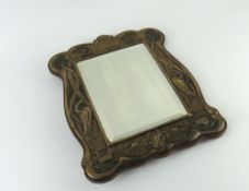 A small silver-framed mirror with wooden back
