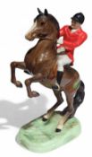 A Beswick porcelain huntsman rearing on horse