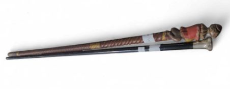 A naively carved wooden walking cane with a monkey
