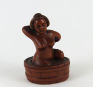 A Japanese netsuke depicting a nude female bathing