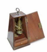 A brass microscope contained in a metronome-style