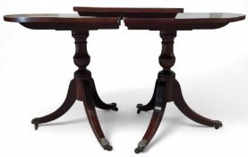 A mahogany twin pillar extendable dining table