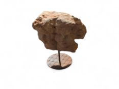 A chiselled rose-coloured stone figure