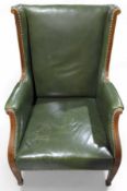 An Edwardian dark-green leather arm chair