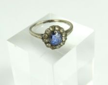 A mid-blue sapphire and white stone cluster ring,