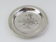 A smooth silver dish with engraved and darkened de