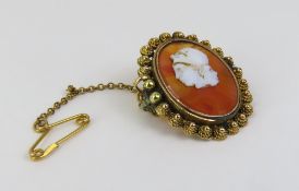 An unusual cameo brooch, the carnelian with a carv