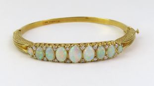 An 18ct gold white opal and diamond set bangle, in