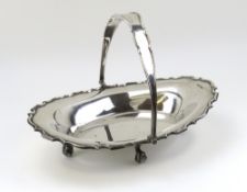 A silver fruit basket with long swing handle