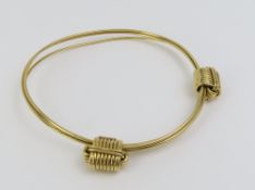 A gold three strand bangle