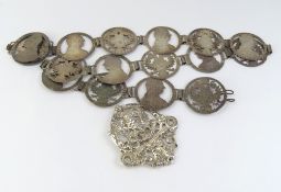 A silver chatelaine top and a metal belt of coins
