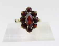 A garnet cluster ring, the marquise cut centre sto