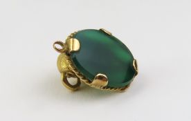 An unmarked yellow metal green-stone pendant