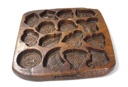 A hardwood Kashigata mould with naive carvings of flora and fauna,