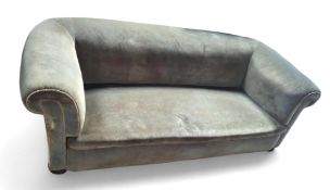 A greyish blue velvet low sofa, with rounded