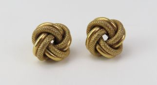 A pair of 9ct gold knot stud earrings, the open work wi