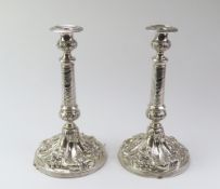 A pair of decorative white metal candlestick holders