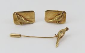 A pair of pheasant shaped cufflinks set onto a re