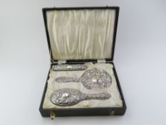 A cased silver backed dressing table set